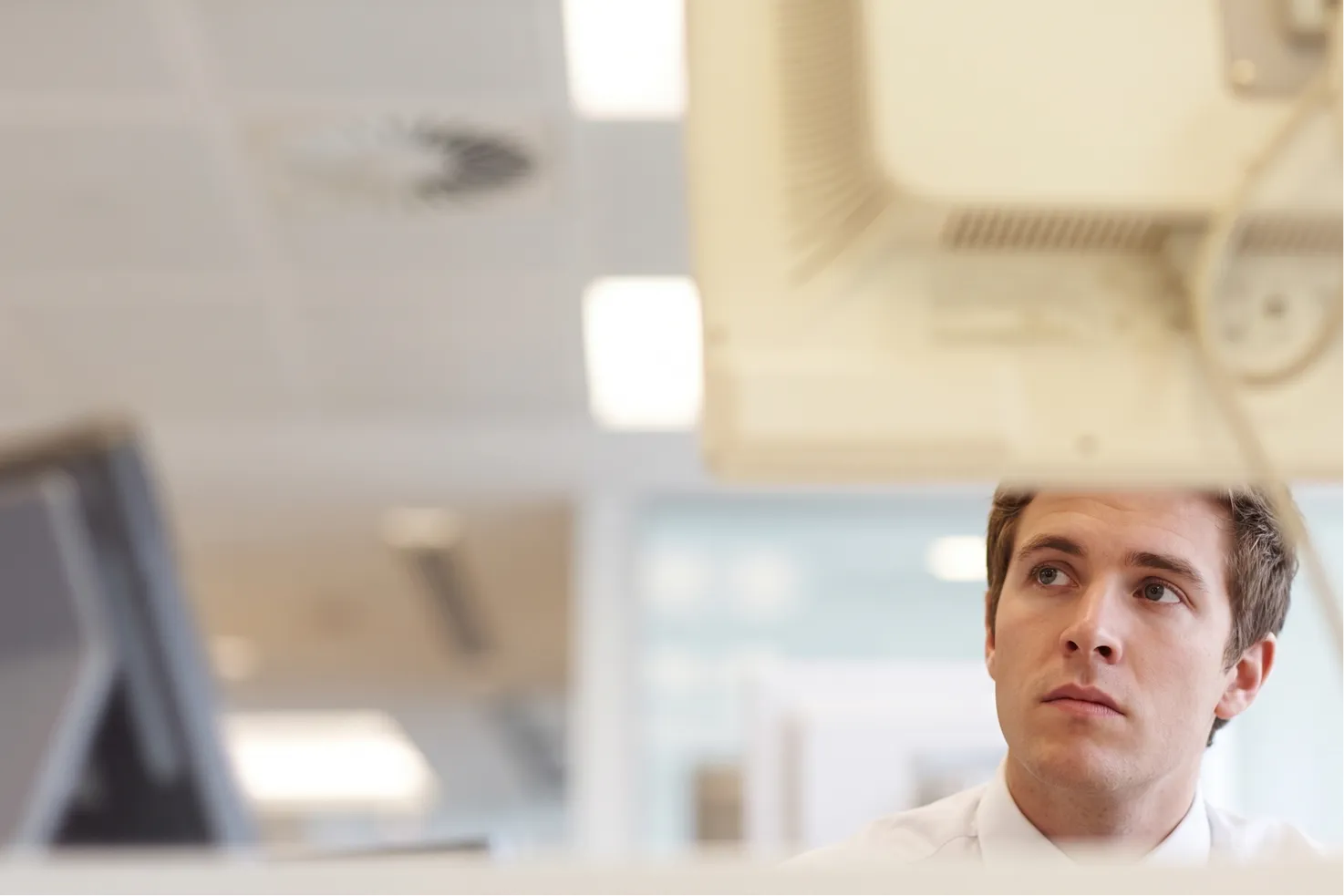 A young professional at a workstation with monitors