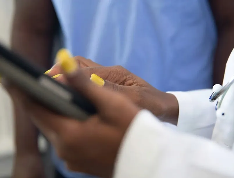 A clinician's hands on a tablet